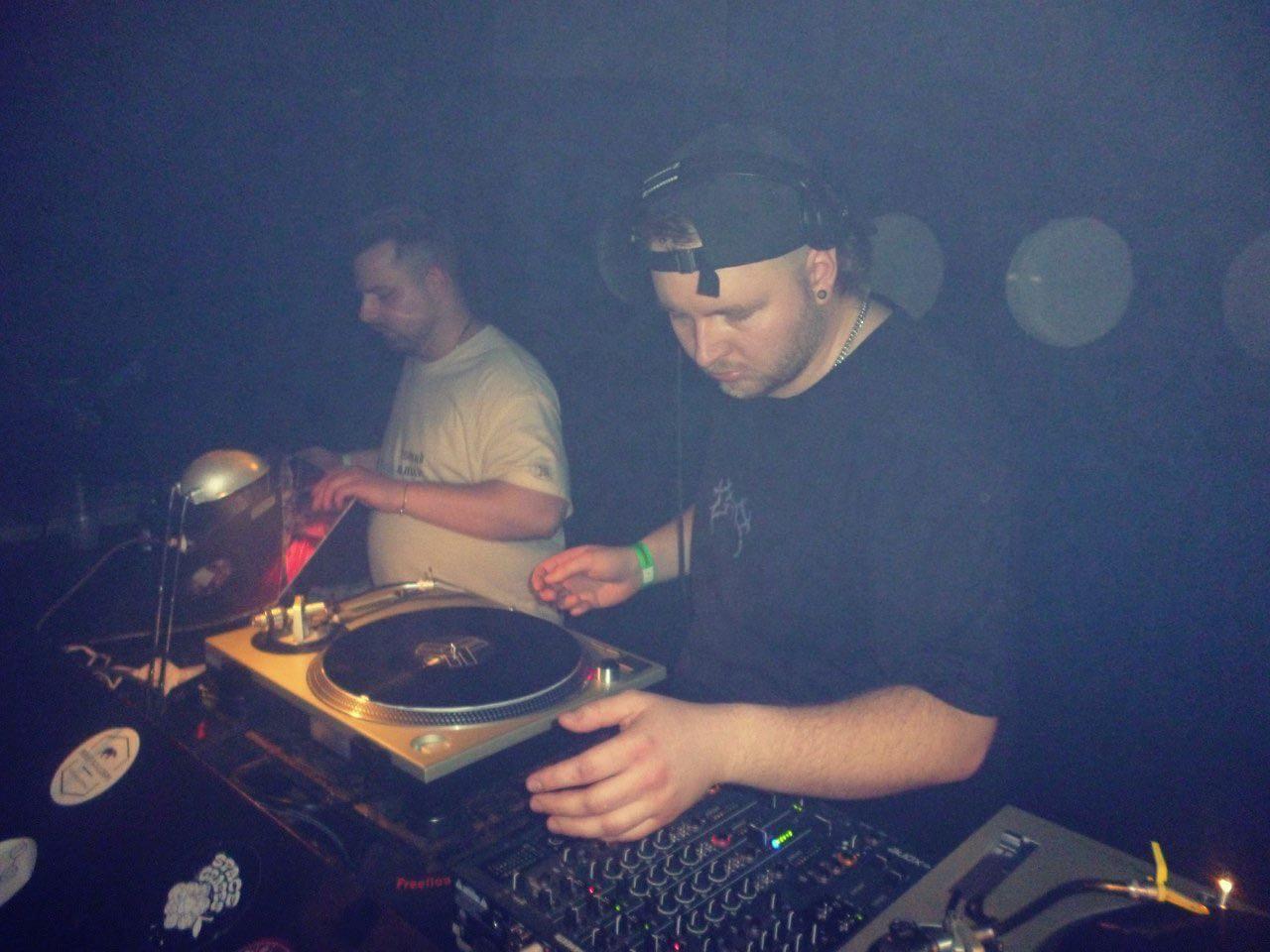 REEZA working the vinyl decks in a packed DJ booth